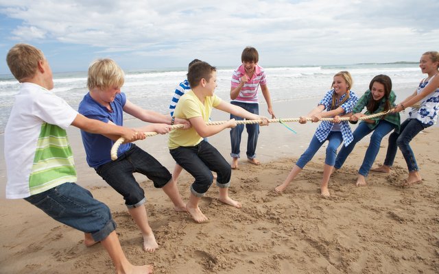 Tug of war played by teens on a beach